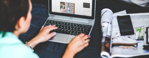 Kvinde med laptop skriver på hjemmeside
